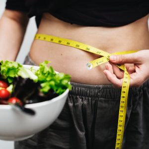measuring belly holding salad